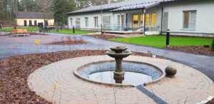 Foto av servihuset Lyckans bakgård. I fronten en fontän.