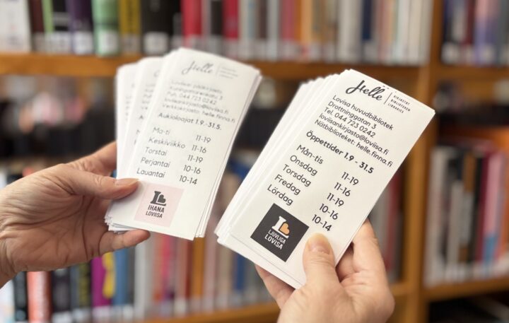 Kuvituskuva, kädet pitelemässä Loviisan kirjaston infolappuja