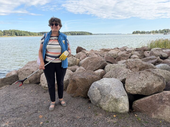 Opas keräämässä roskia roskakävelyllä.